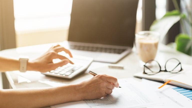 Self-Assessment paper tax return form and calculator on a desk